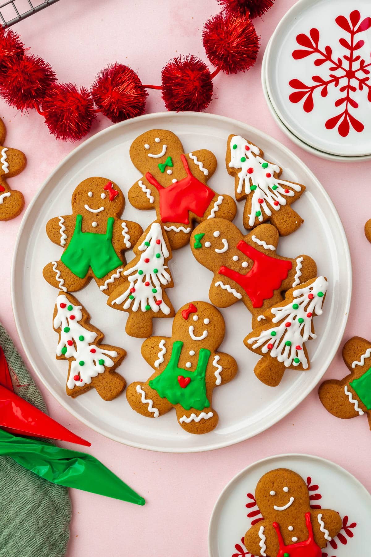 Platter of freshly baked thick frosted gingerbread cookies with holiday decorations