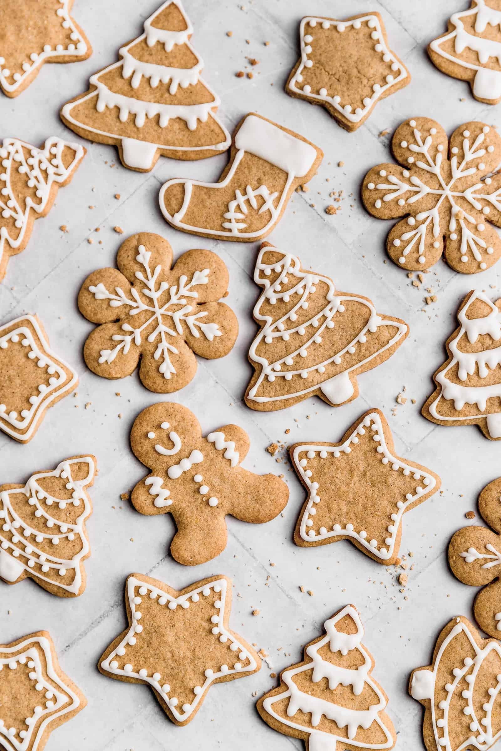 beautifully decorated gingerbread cookies with white royal icing and festive background