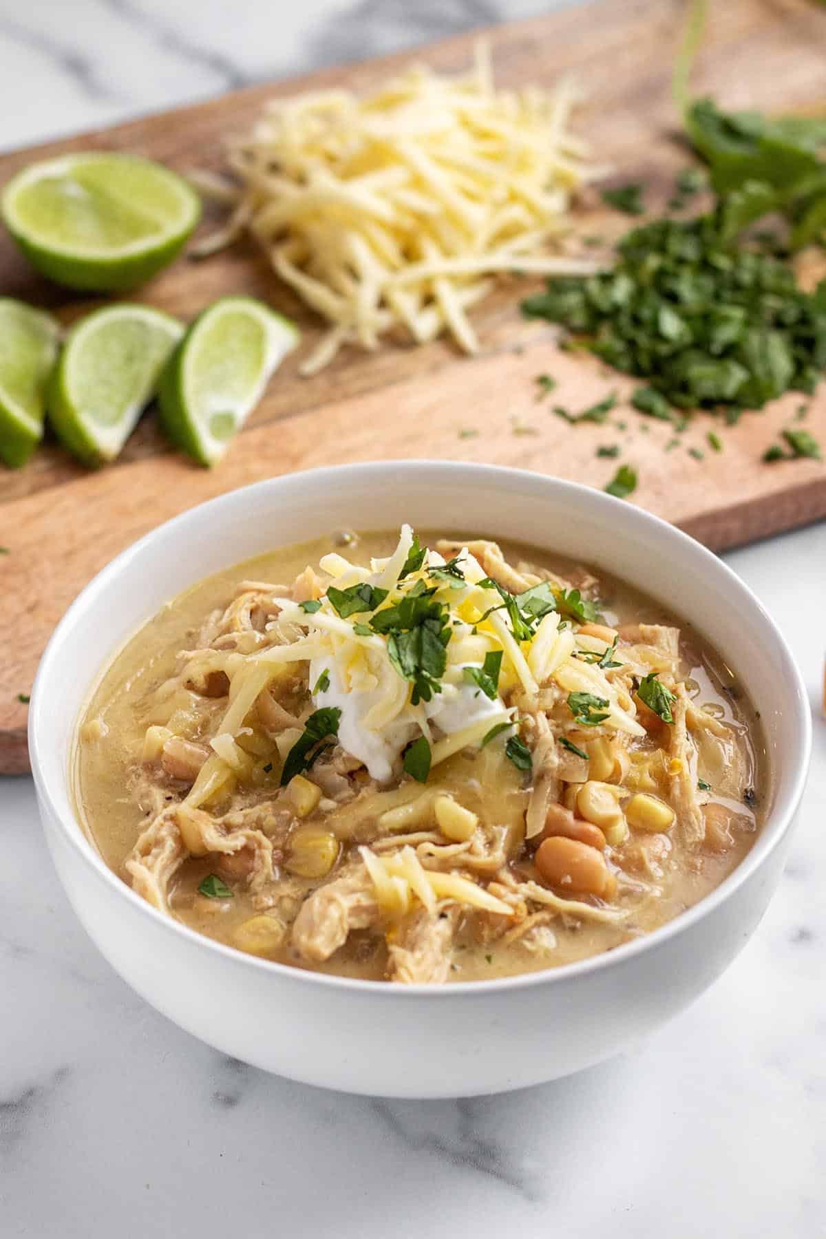 bowl of creamy white chicken chili topped with cilantro and cheese