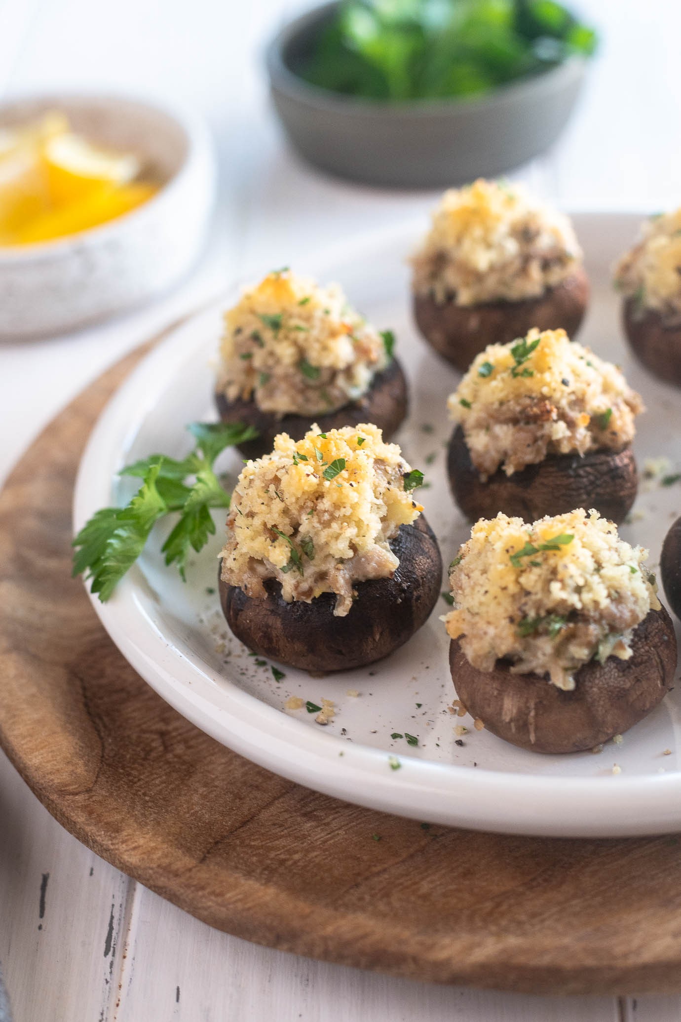 appetizer platter of golden brown sausage stuffed mushrooms with fresh herbs
