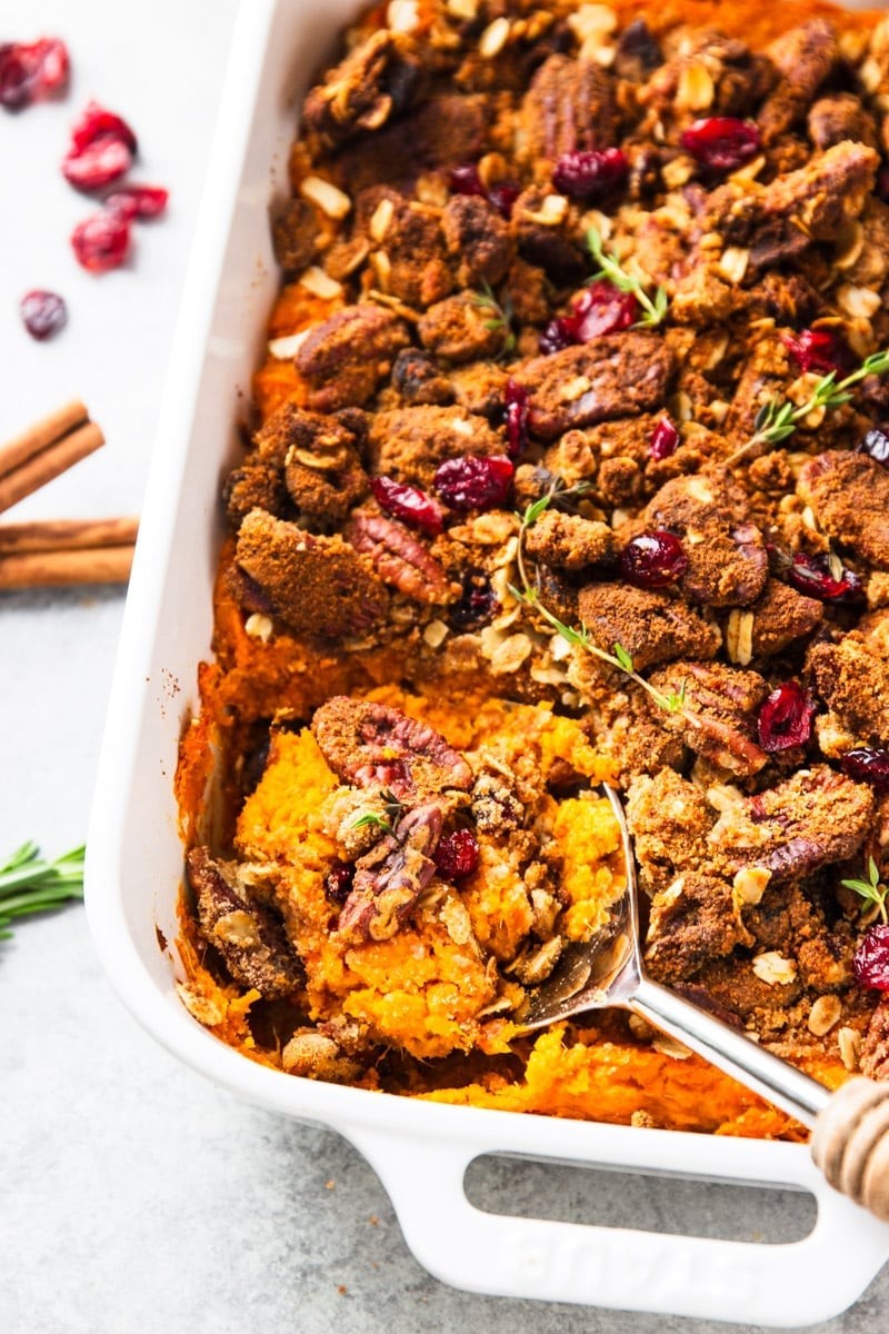 Glistening roasted sweet potato casserole with golden pecan topping, autumn colors, rustic setting
