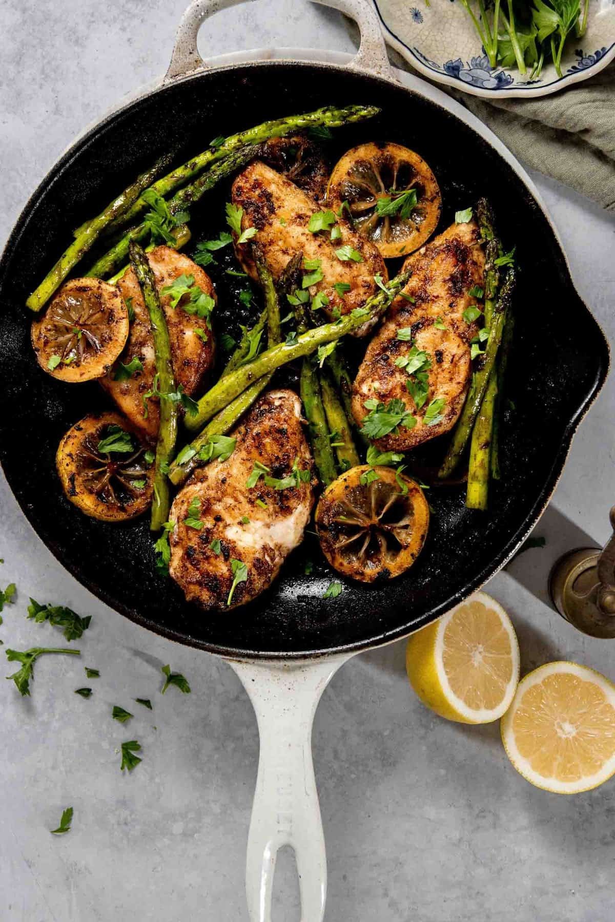 vibrant lemon herb skillet chicken with fresh parsley, golden brown chicken thighs in cast iron pan