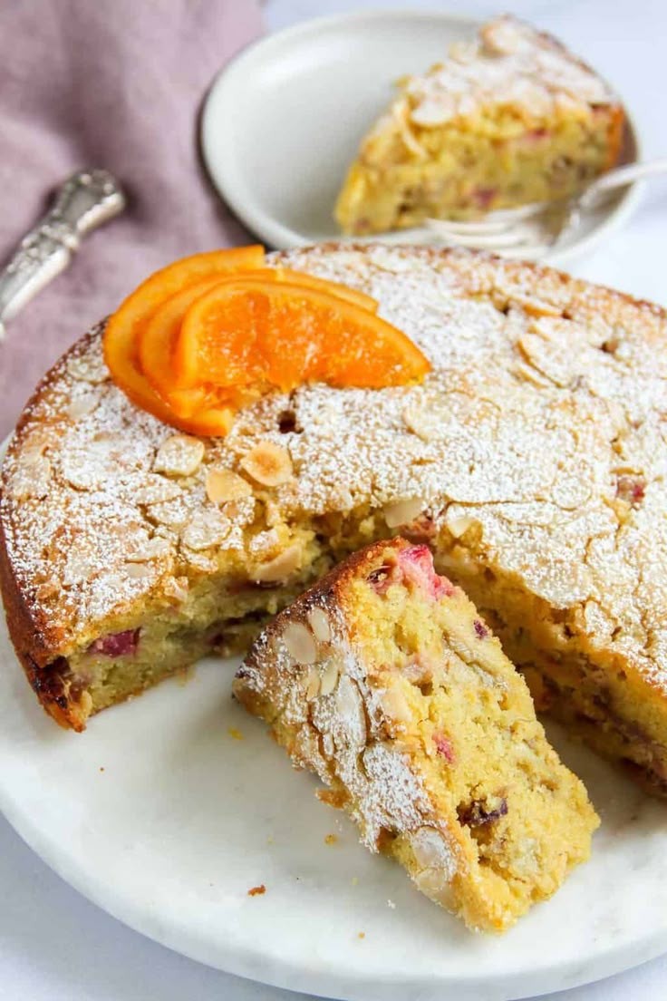 slice of rhubarb cake with cardamom and orange zest on a plate, styled with flowers