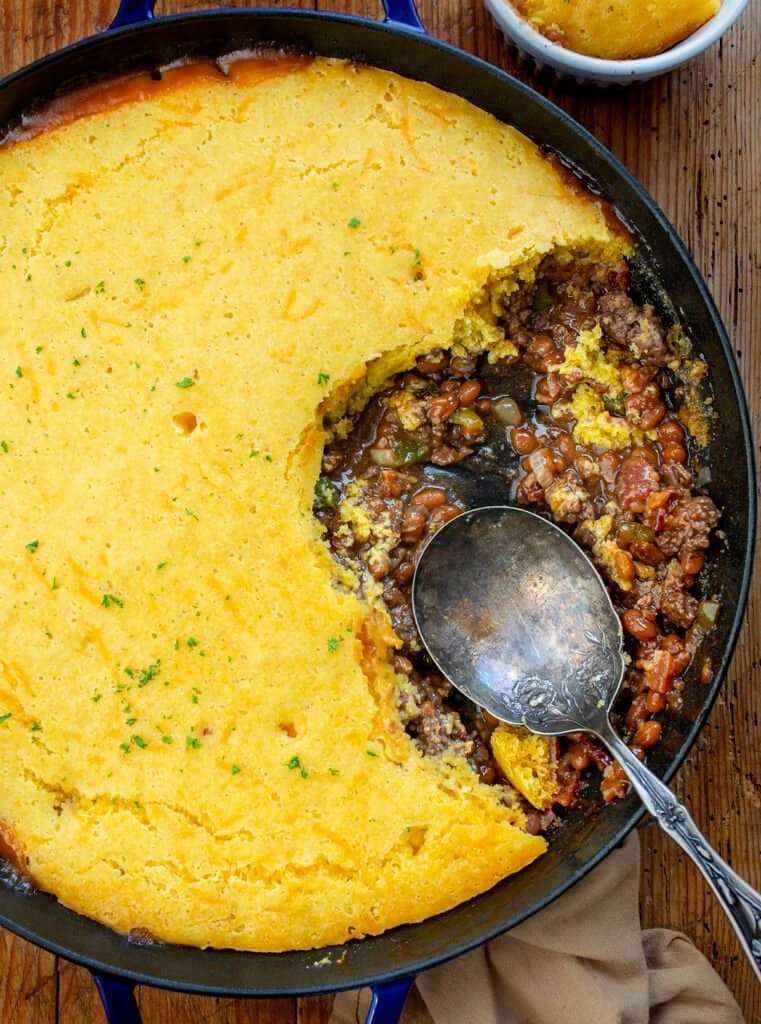 Rustic cowboy casserole with beef, corn, and golden cheesy topping, served in a cast iron dish