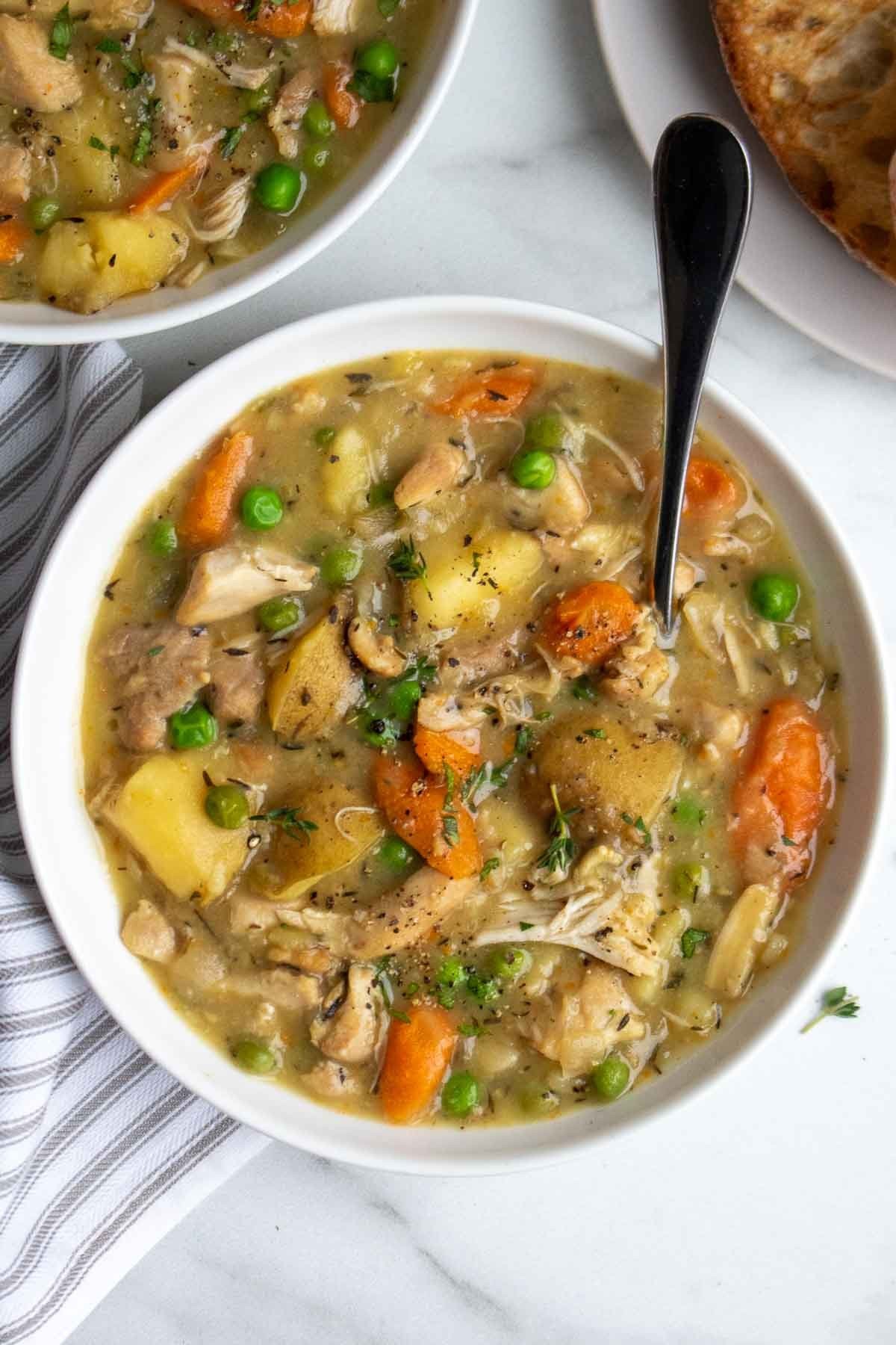 A steaming bowl of slow cooker chicken stew with vegetables