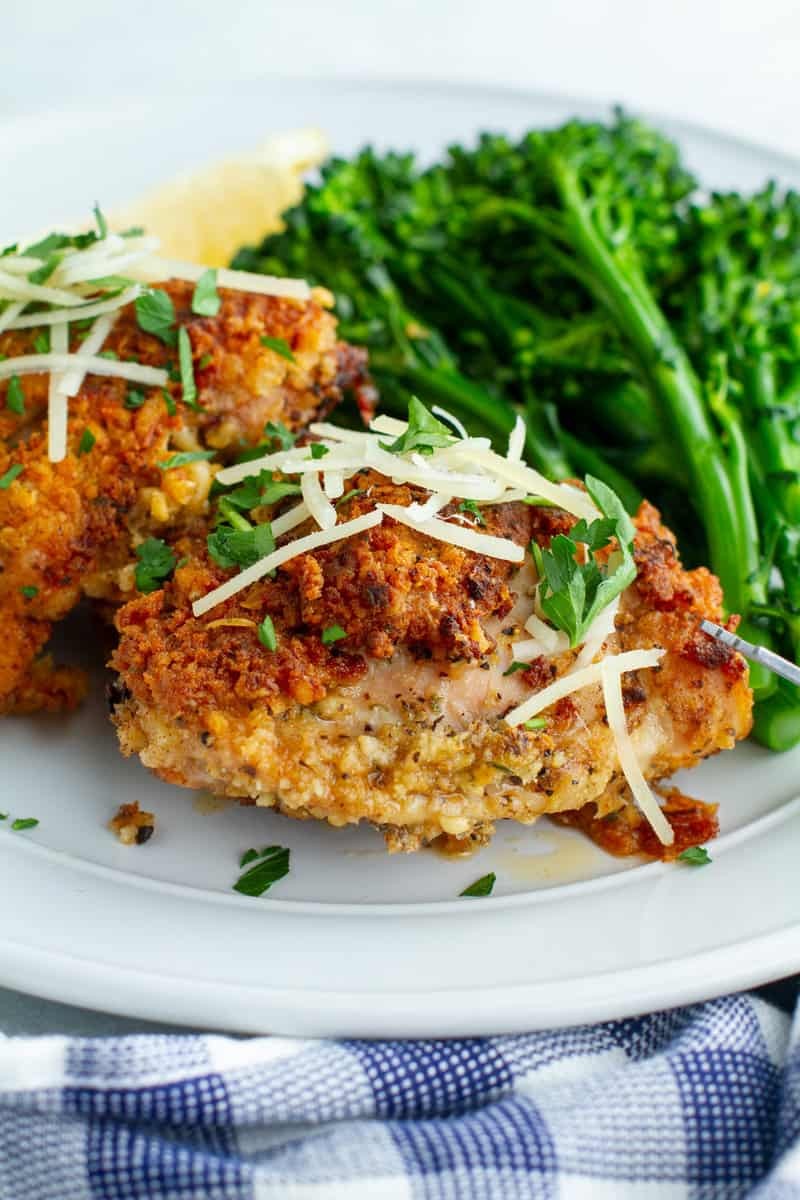 Crispy Parmesan chicken thighs with herbs, close up