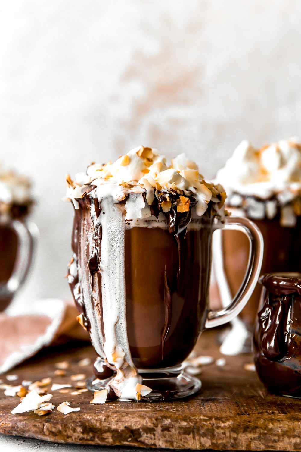 Delicious coconut hot chocolate with whipped tropical cream and toasted coconut flakes, cozy ambiance