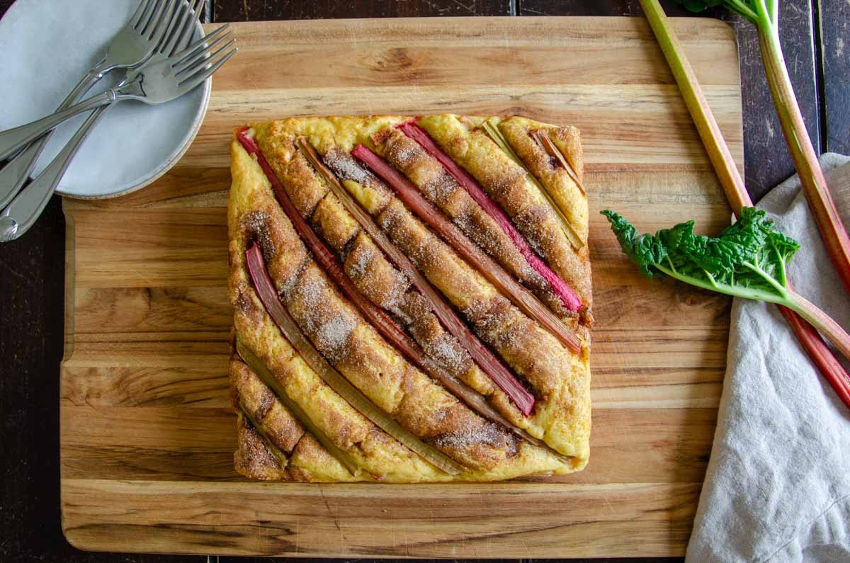 slices of freshly baked rhubarb rye bread on a wooden cutting board with a pat of butter