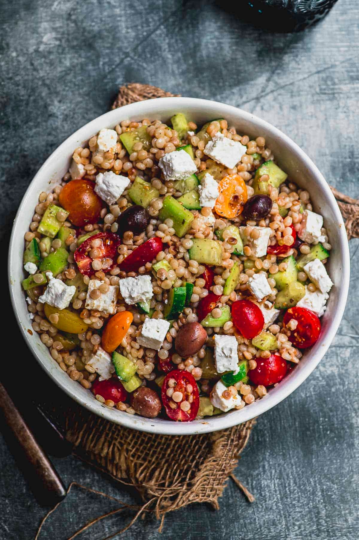 Greek pasta salad with quinoa and fresh parsley served in a bright bowl