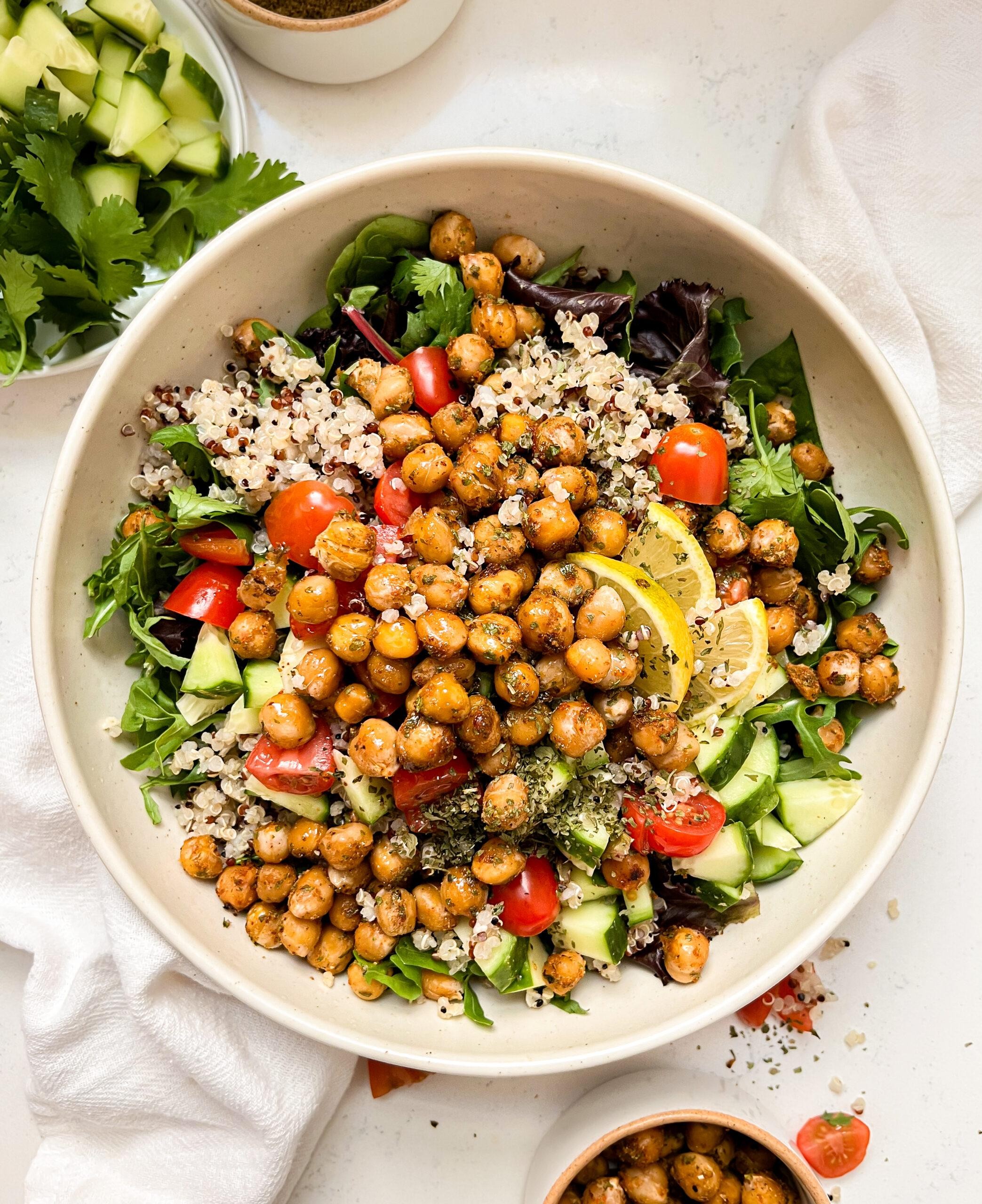 quinoa bowls with roasted vegetables and chickpeas on a wooden table