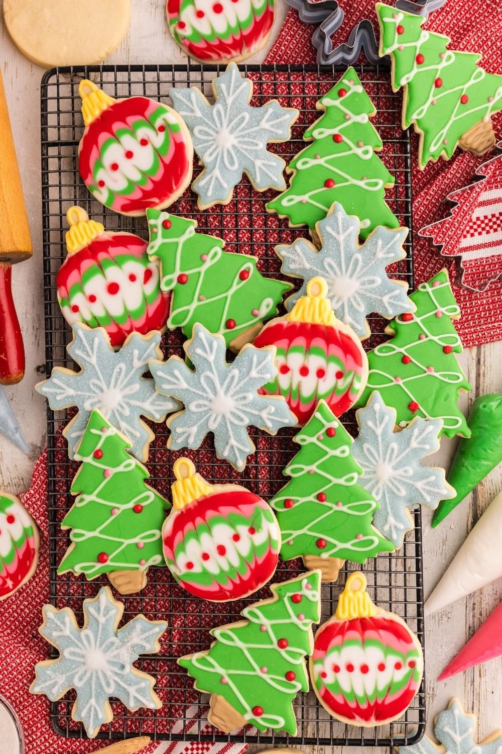 beautifully decorated cut out sugar cookies on a cooling rack, holiday themed