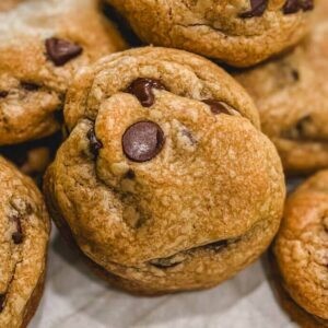 Pile of golden brown butter chocolate chip cookies on a cooling rack, close up