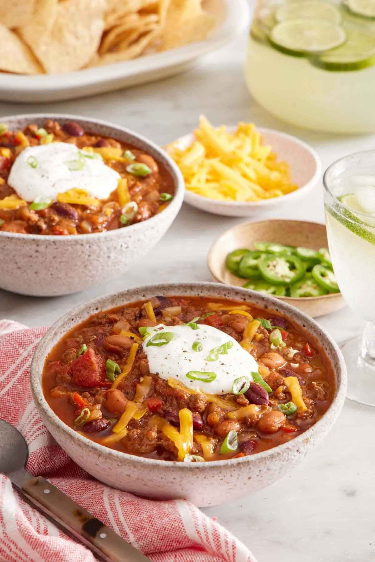 bowl of homemade chili with toppings like shredded cheese, sour cream, and green onions