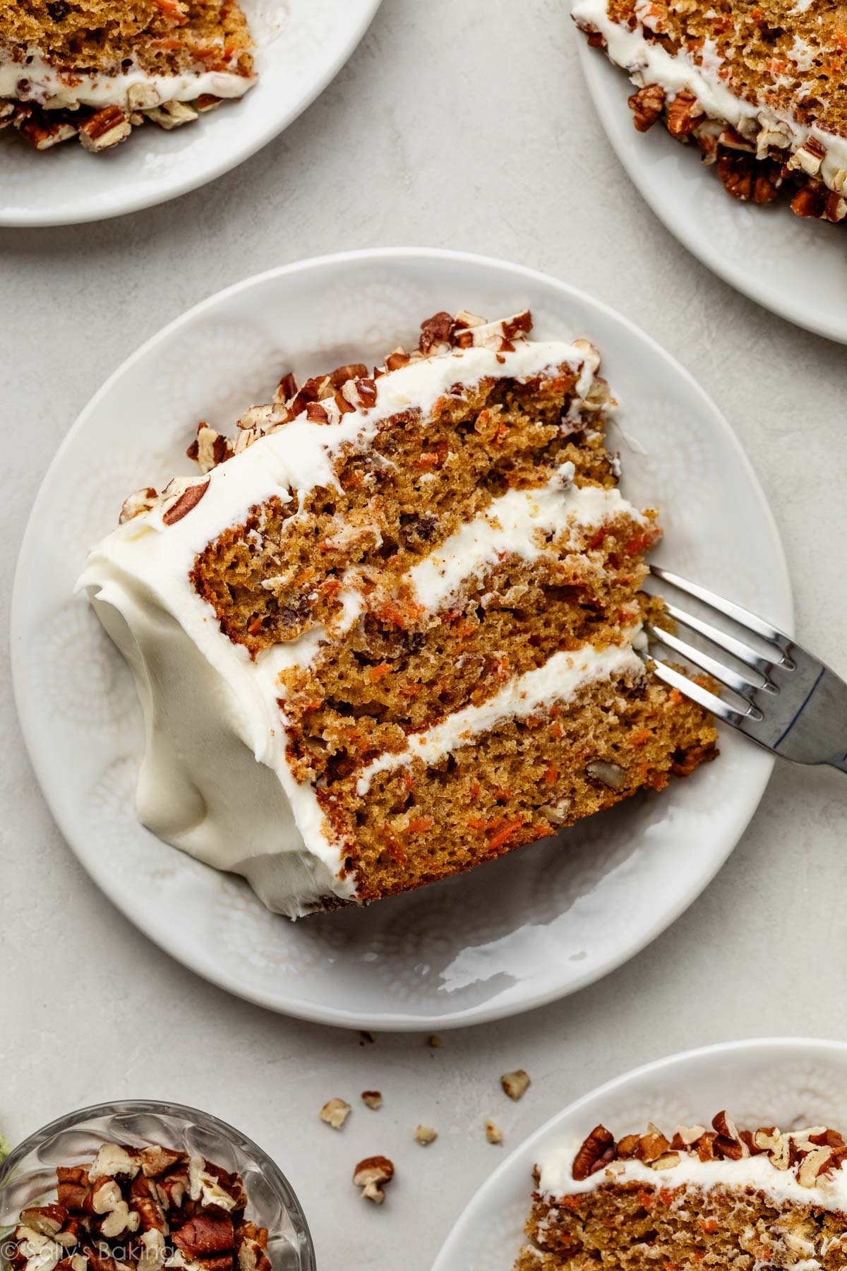 overhead shot of a frosted carrot cake with nuts and cream cheese frosting