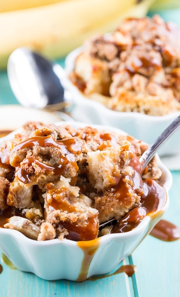 Peanut butter banana bread pudding with sliced bananas and a scoop of vanilla ice cream on top, served in a rustic baking dish