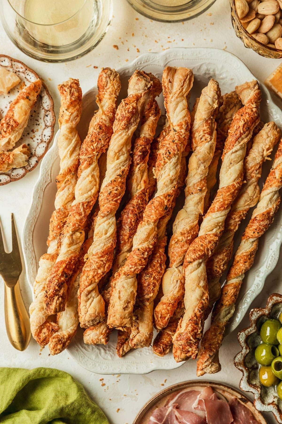 savory parmesan puff pastry twists on a baking sheet, golden brown