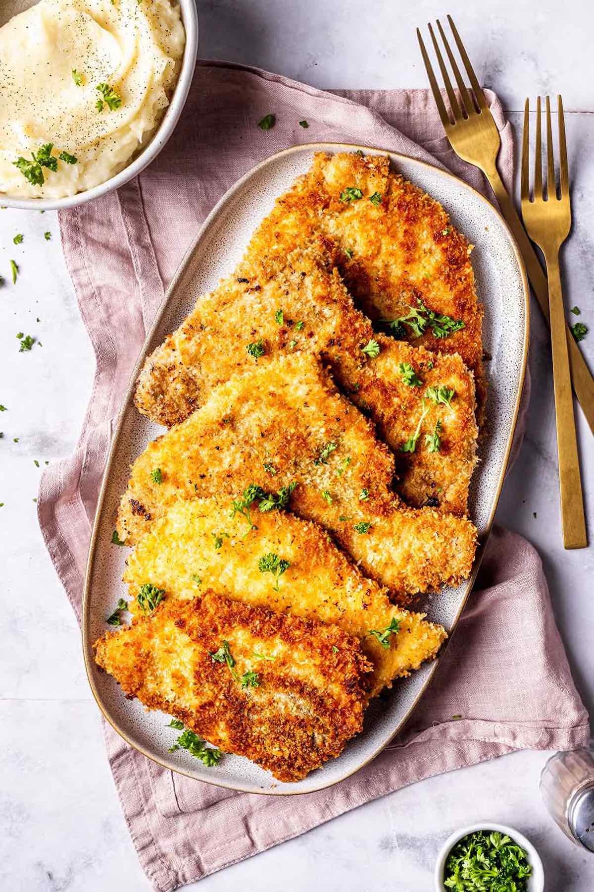 Skillet turkey cutlets with golden crust on a plate with sides