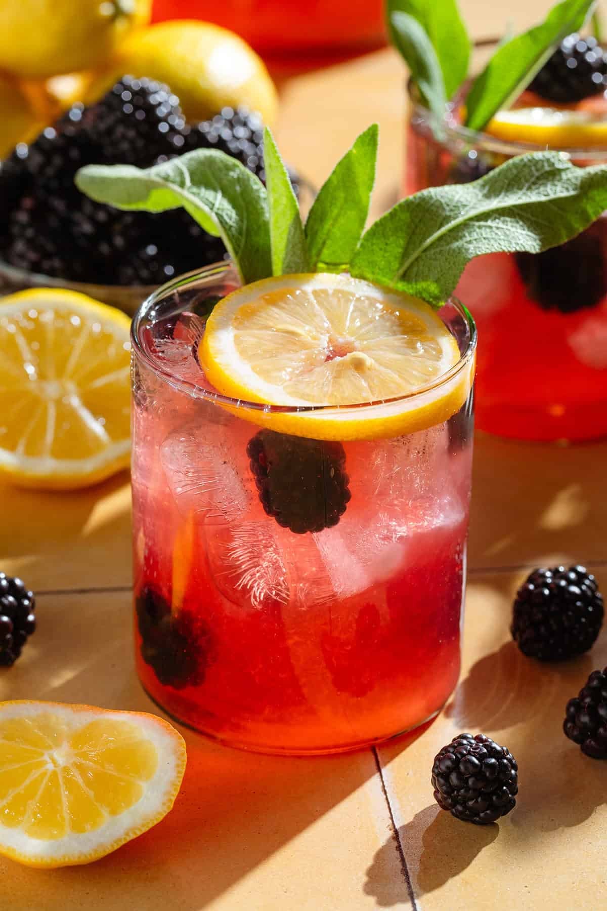 pitcher of blackberry sage lemonade with lemon slices and fresh blackberries