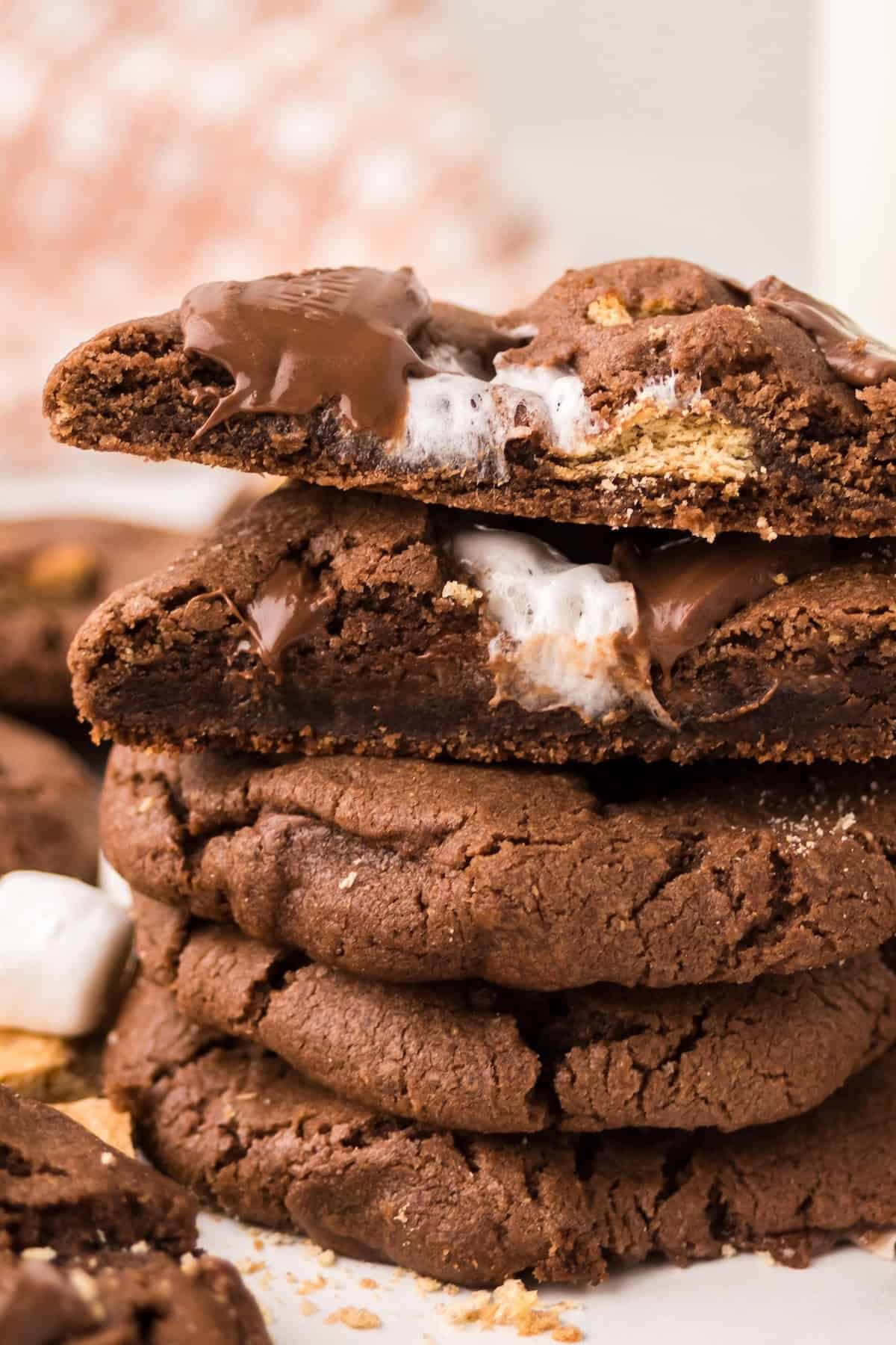 close-up of warm, gooey chocolate chip cookies on a cooling rack, some broken to show melted chocolate inside