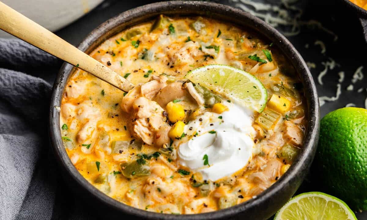 bowl of cream cheese white chicken chili topped with cilantro and a dollop of sour cream