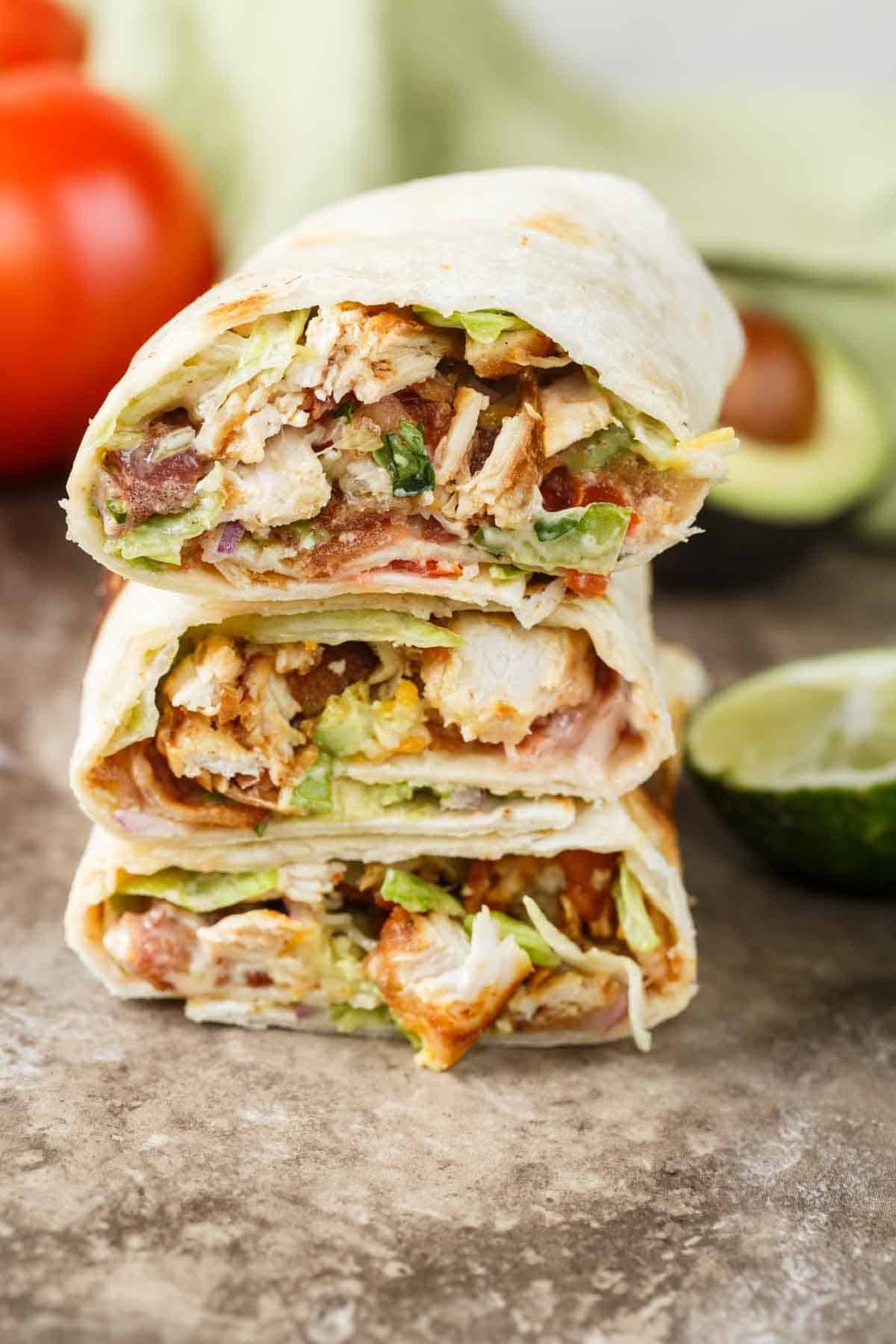 Close-up of a vibrant, freshly made hearty chicken wrap, cut in half, showcasing ingredients
