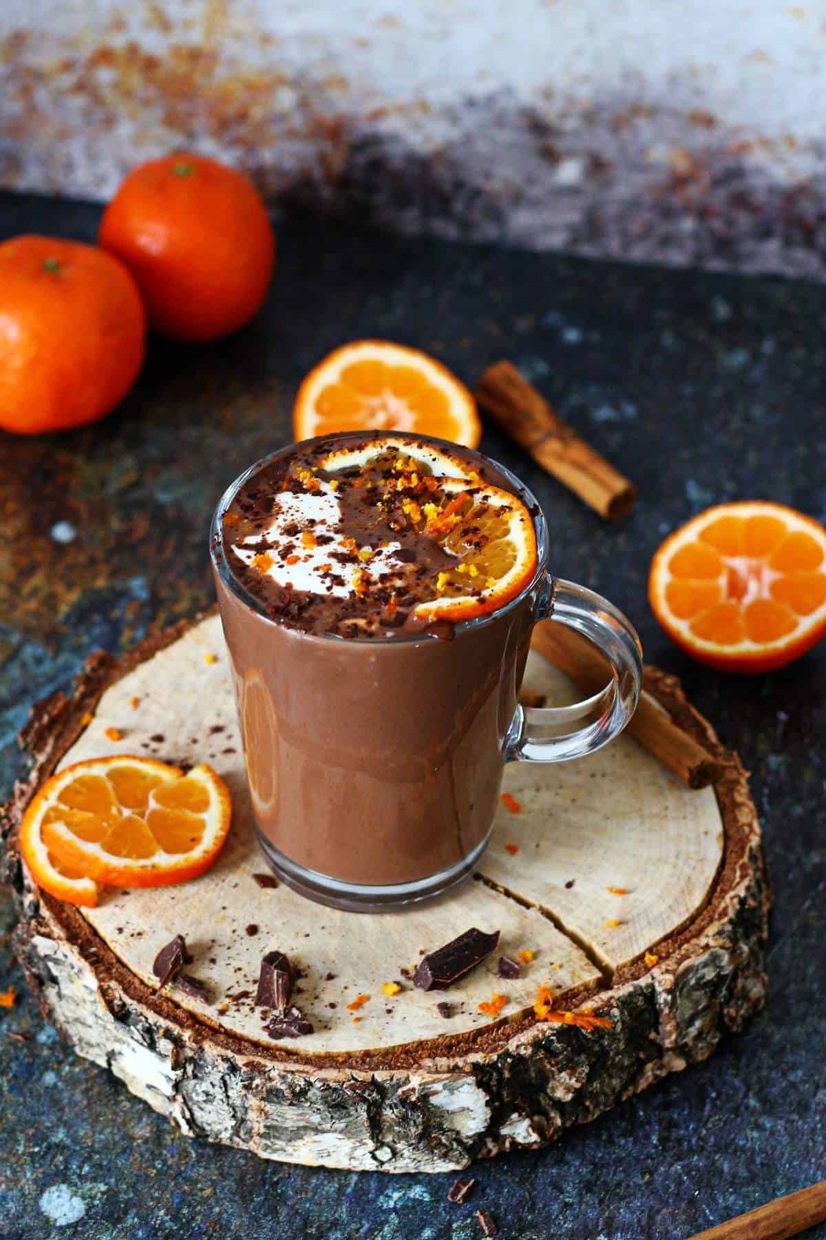 steaming mug of orange infused hot chocolate with orange zest garnish, cozy winter setting