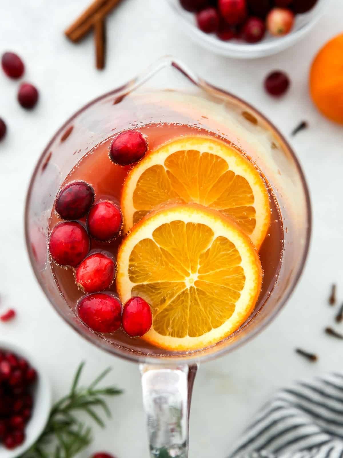 Vibrant holiday spiced rum punch with citrus slices and cranberries in a punch bowl