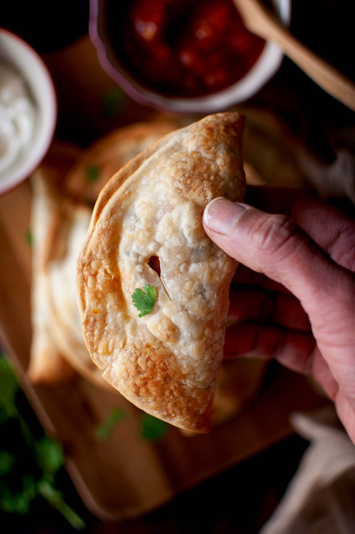sweet potato and black bean empanadas on a rustic wooden board