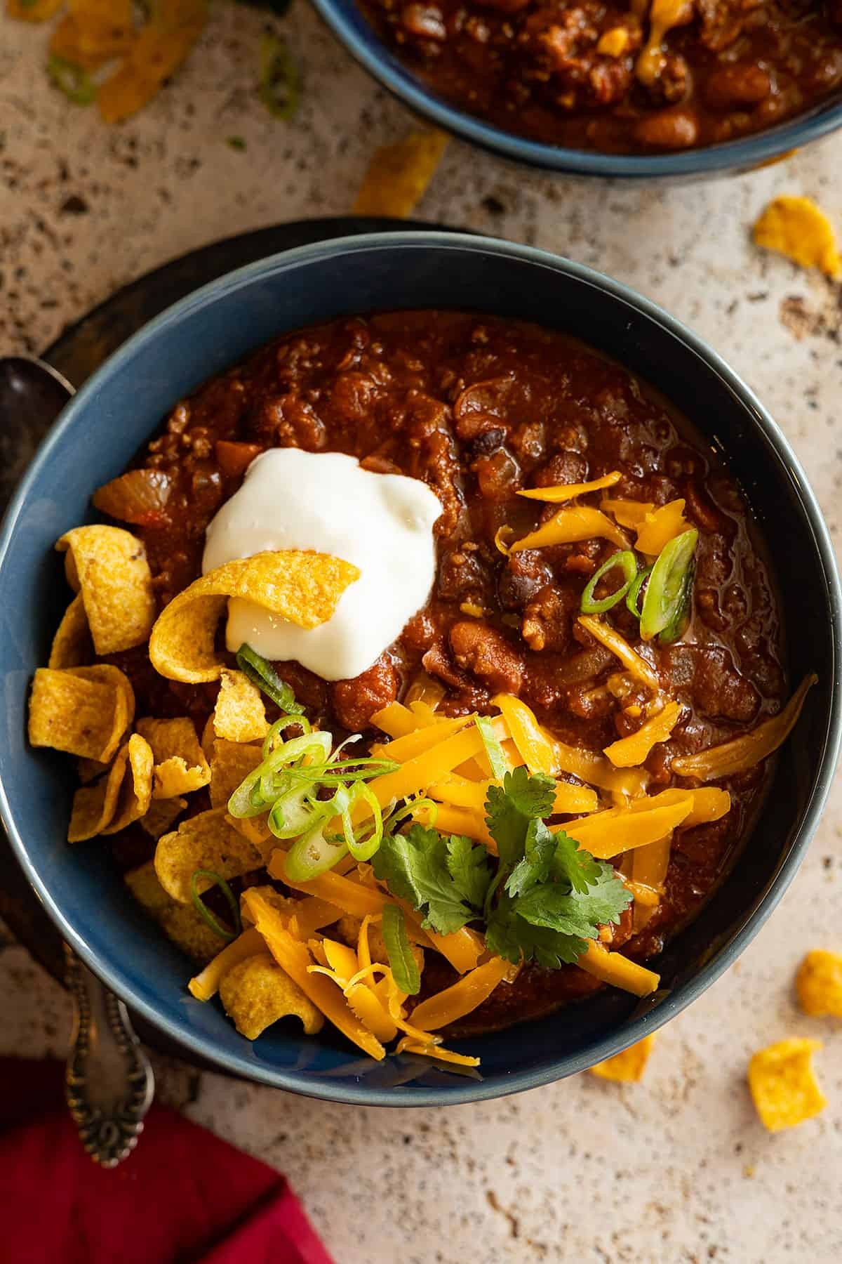 A bowl of slow cooker chili topped with cheese and sour cream