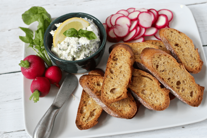 freekeh cream cheese spread on a baguette with fresh herbs