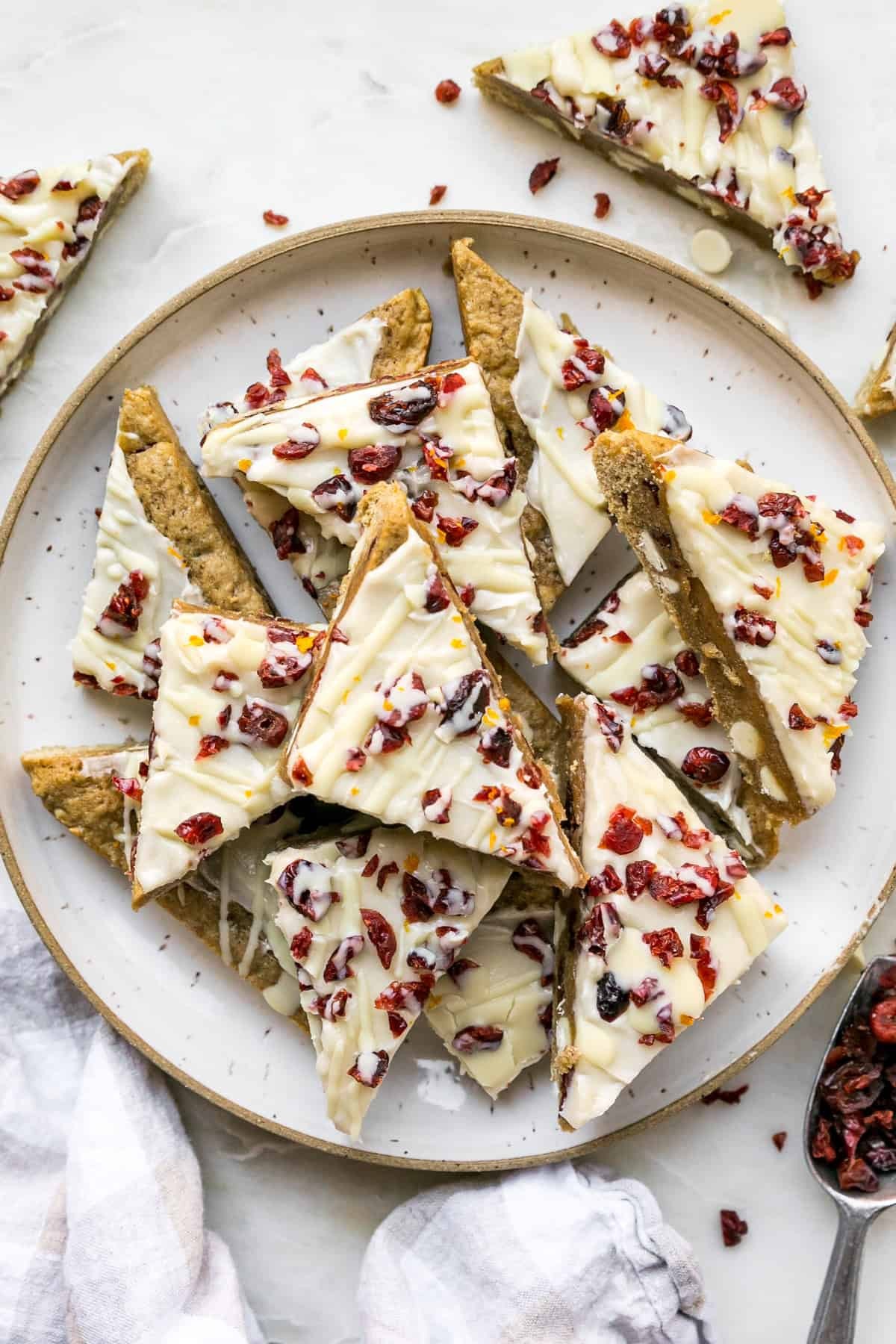 festive cranberry bliss bars with white chocolate drizzle on a rustic wooden board, holiday setting