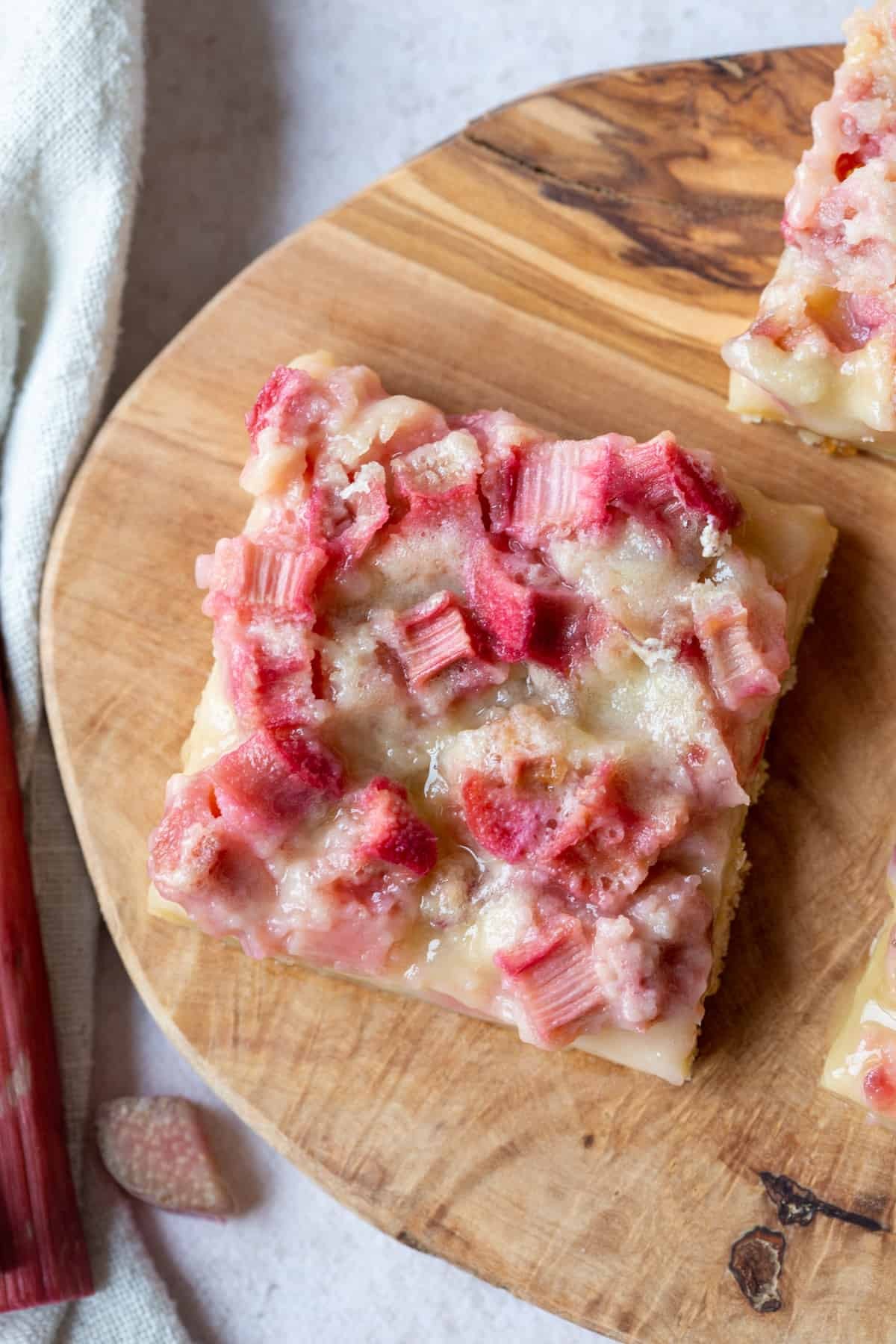 Macadamia Crust Rhubarb Custard Bars on a wooden cutting board