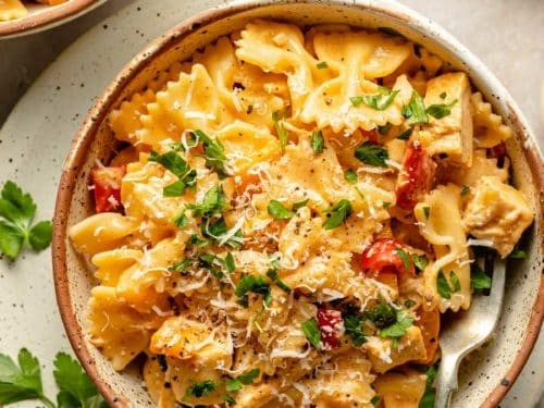 Vibrant creamy Cajun chicken pasta in a bowl with fresh parsley and a fork