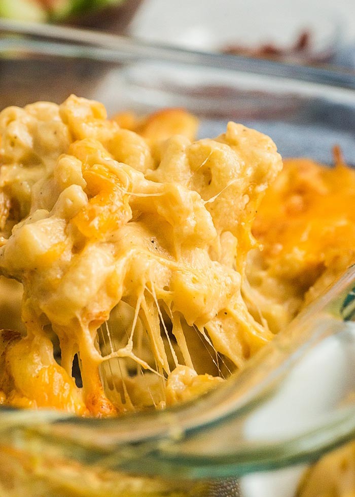 close up creamy mac and cheese bowl with golden baked topping, steam rising, comfort food