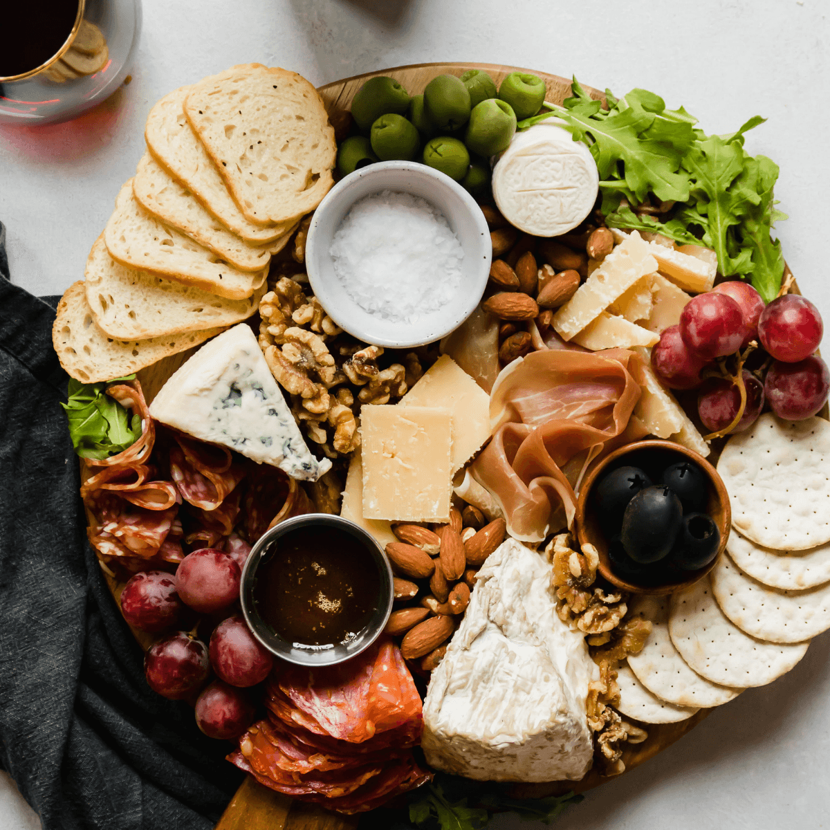 selection of hard cheeses arranged on a wooden board, infused with rosemary