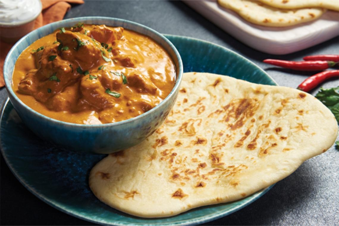 homemade butter chicken served with naan bread