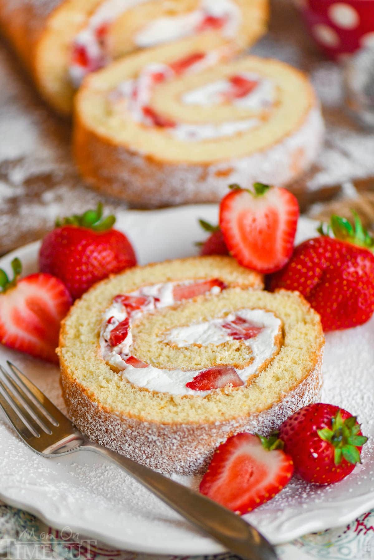 beautifully plated fluffy strawberry shortcake roll with fresh berries and whipped cream