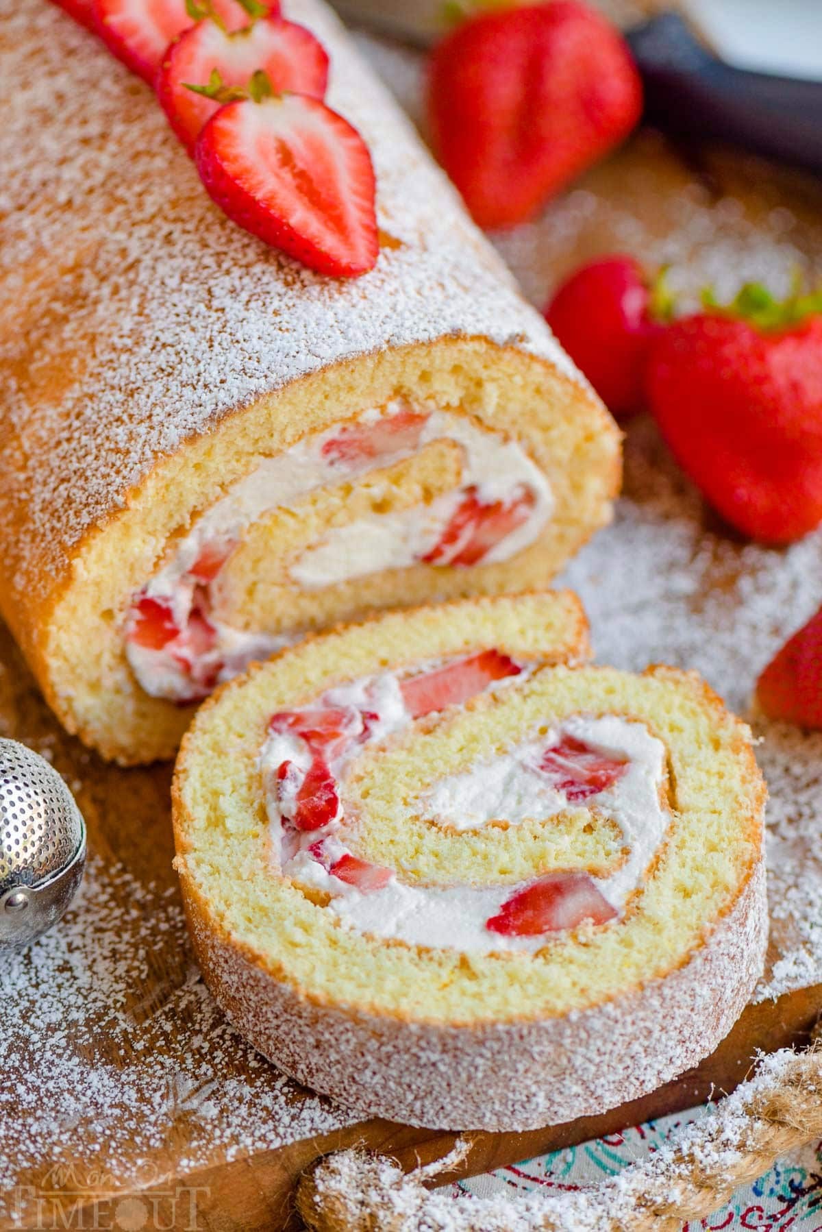 Close-up of a pillowy strawberry shortcake roll with fresh strawberries and whipped cream