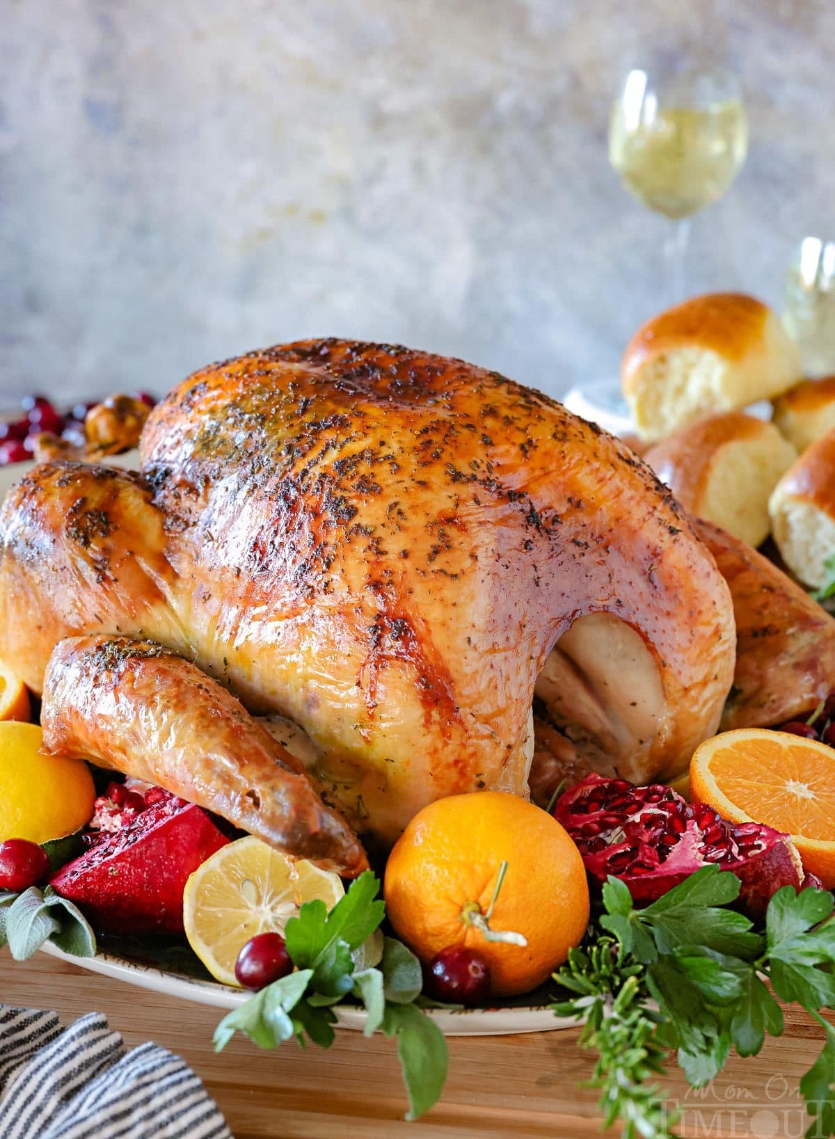 beautifully golden brown whole roasted turkey with herbs on a platter, ready to serve