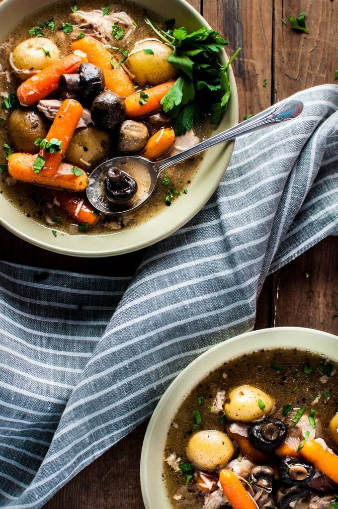 Crockpot chicken being served on a rustic wooden table