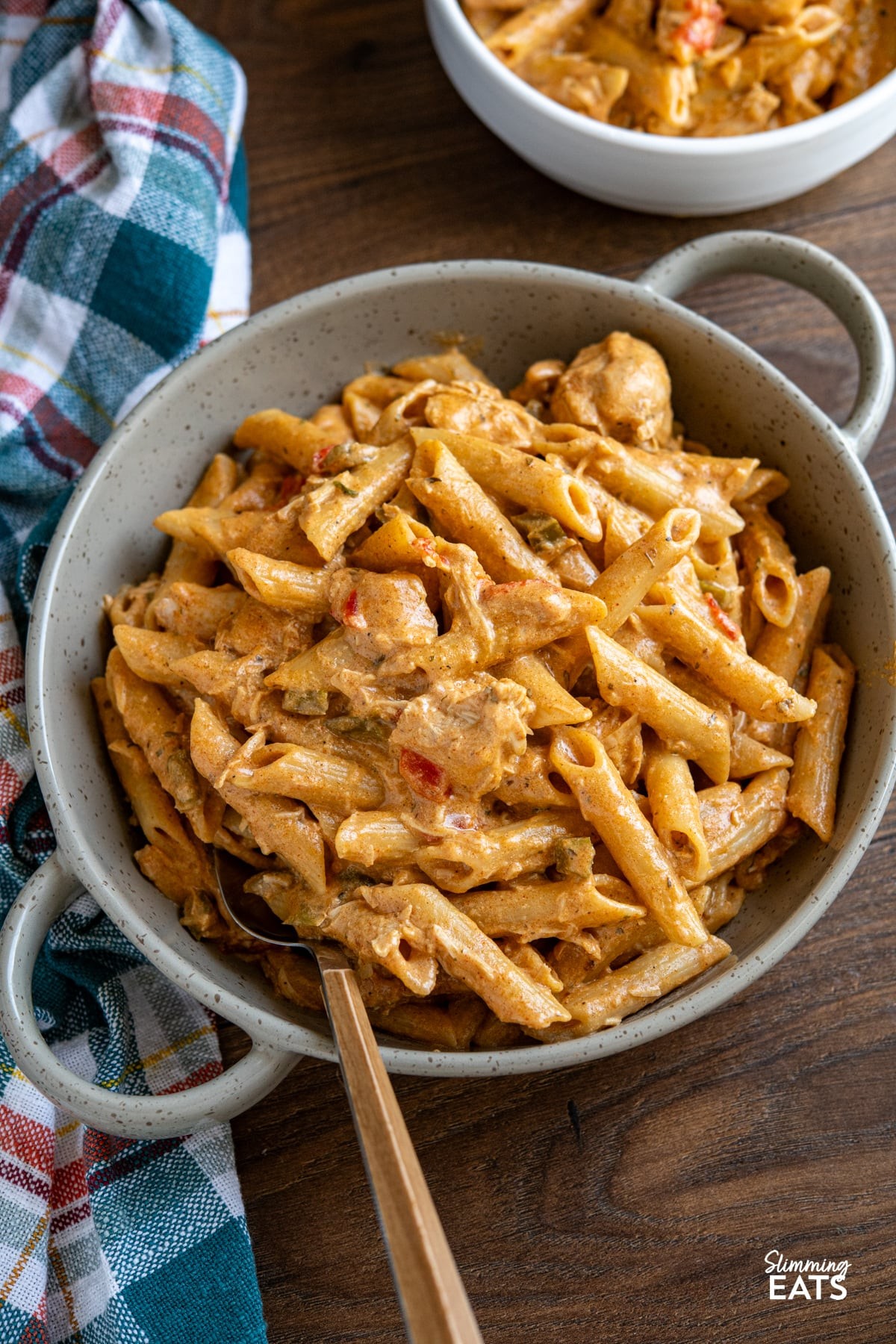 Creamy Cajun Chicken Pasta served in a bowl, with a slow cooker in the background