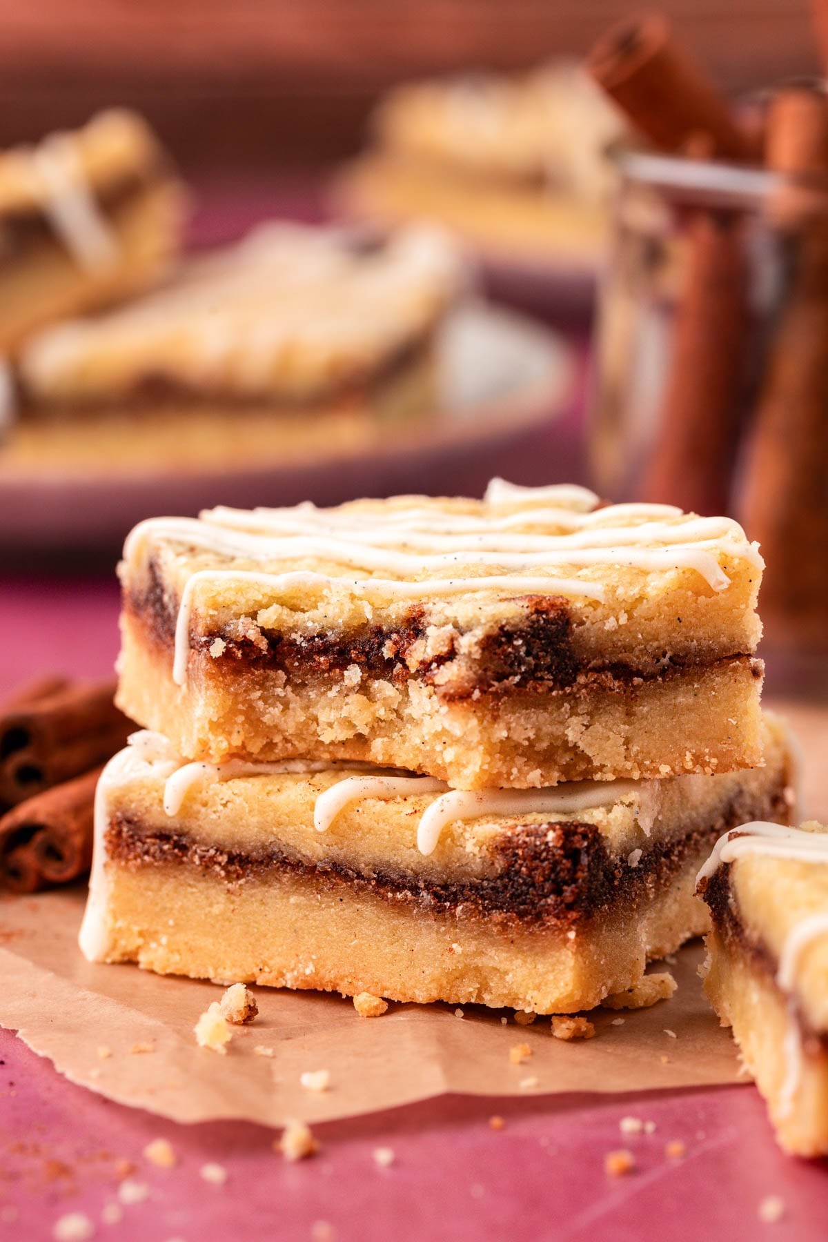 close-up shot of gooey cinnamon cookie squares with frosting drizzle