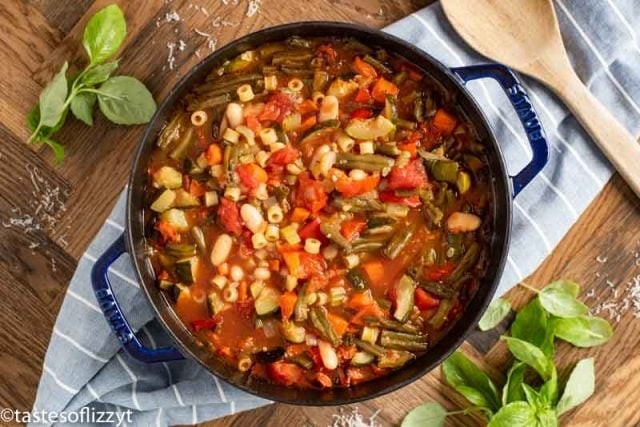 grilled vegetables being added to a pot of minestrone soup
