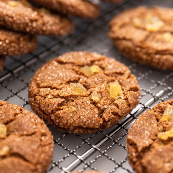 Warm, crinkled molasses cookies dusted with sugar on a cooling rack