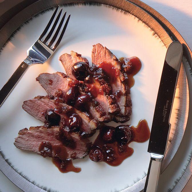 griddle-seared duck breast with cherry sauce on a plate