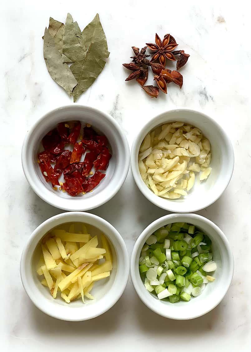 overhead shot of ingredients for star anise chicken quinoa stew laid out on a wooden table