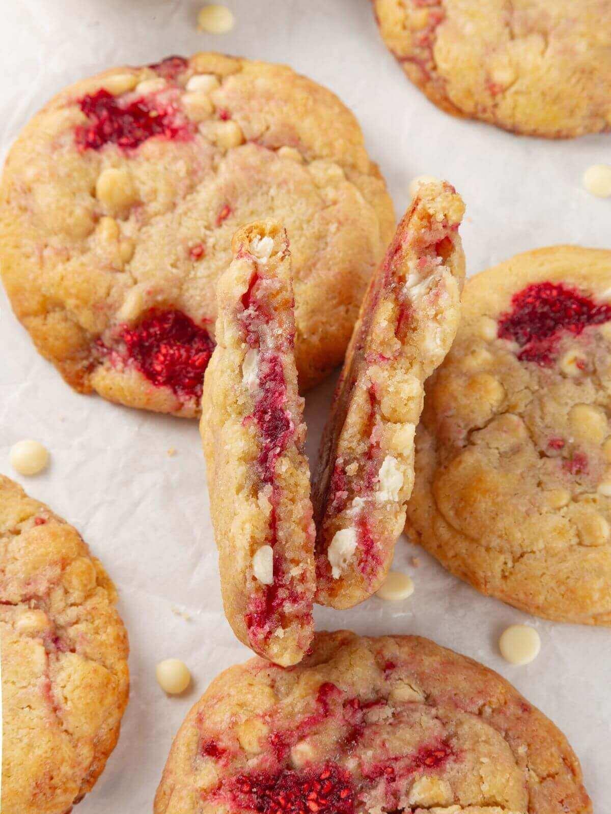 close up of raspberry cookies with white chocolate chips, some broken in half
