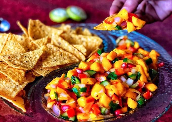 close-up shot of mango salsa nachos supreme with melted cheese and vibrant salsa