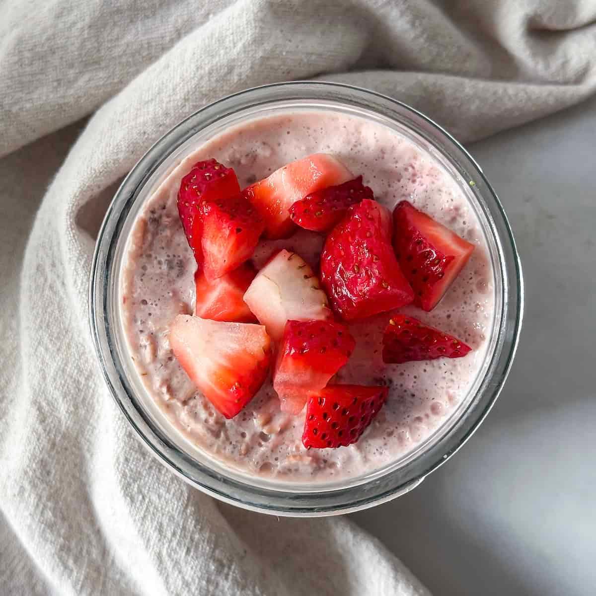 overhead shot of a person preparing strawberry and mint overnight oats