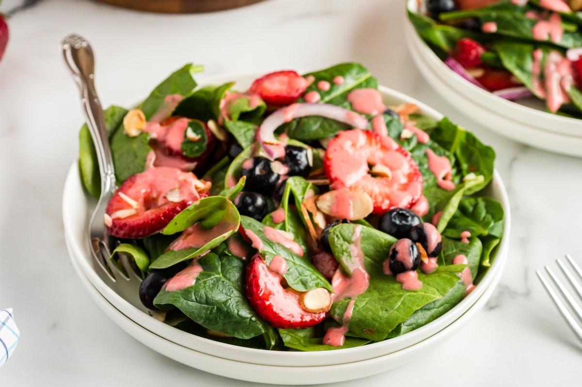 A vibrant strawberry spinach salad with a light vinaigrette dressing